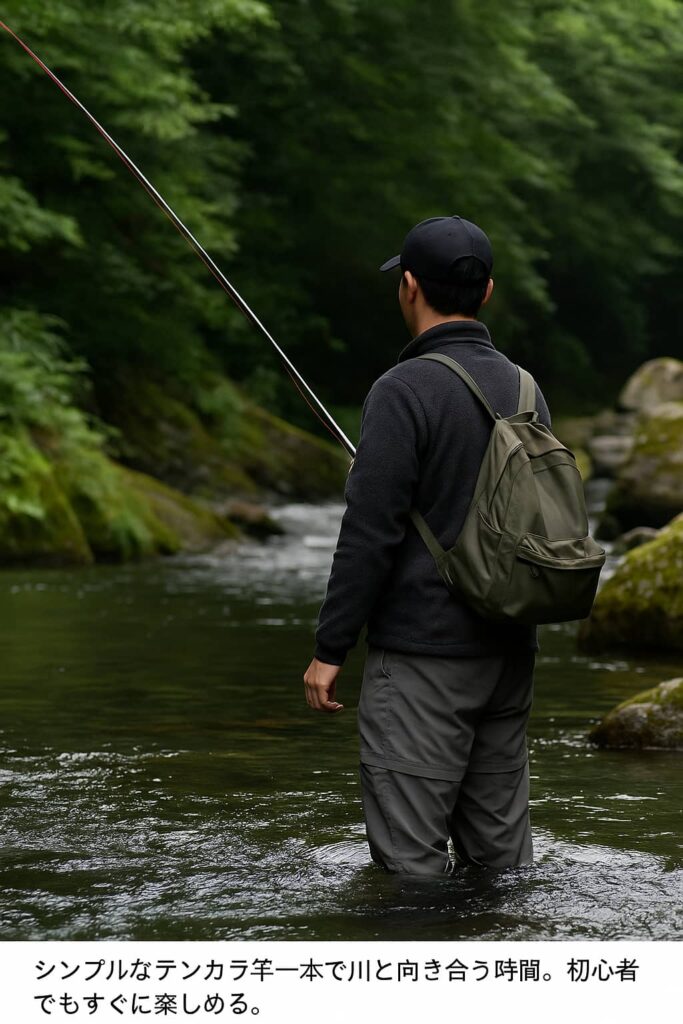 川に立ちテンカラ竿を構える釣り人の後ろ姿