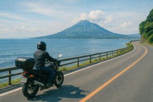 錦江湾沿いを走るライダーと遠くに見える開聞岳の景色